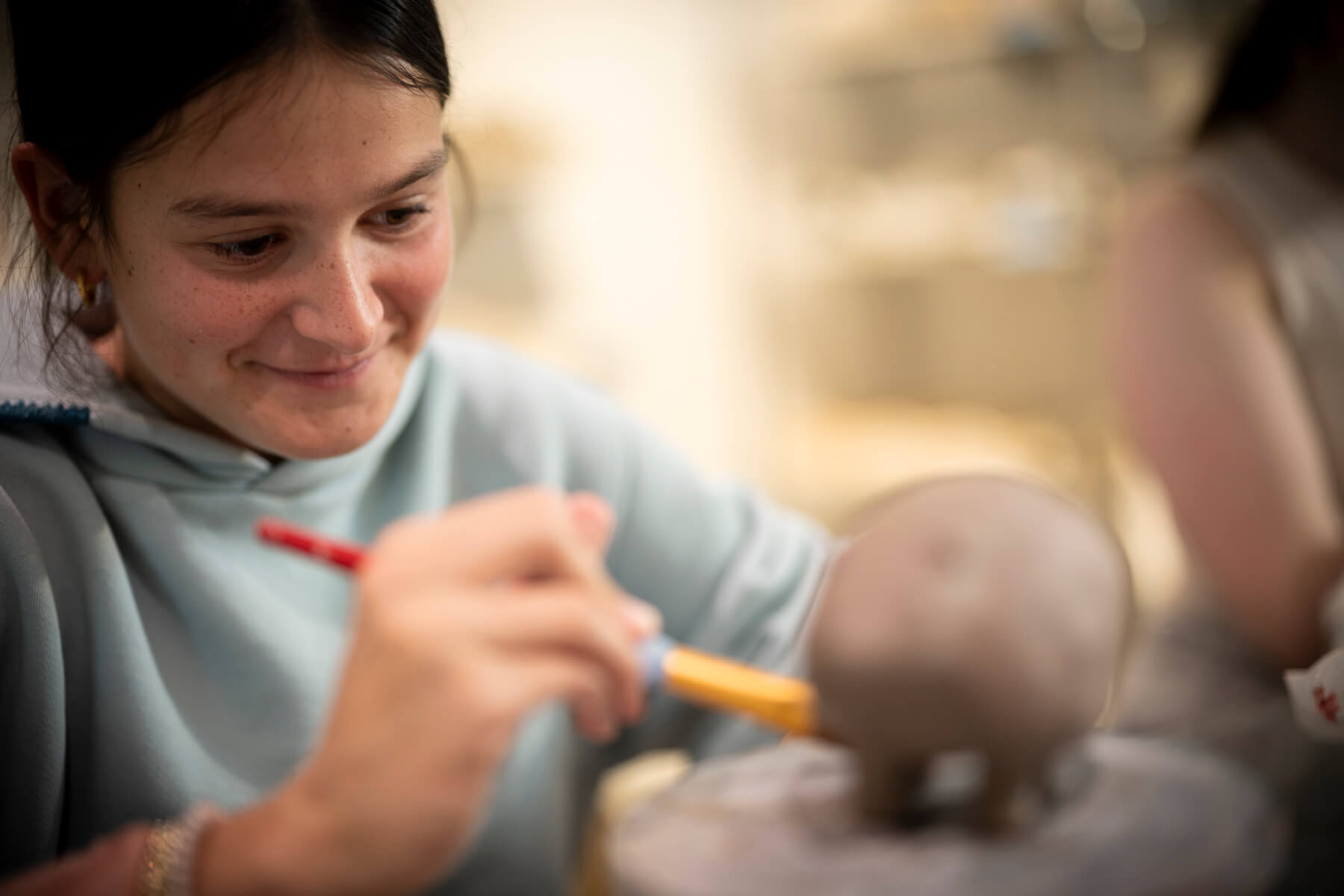 student making pottery