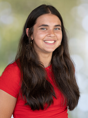 female student with long brown hair wearing red shirt