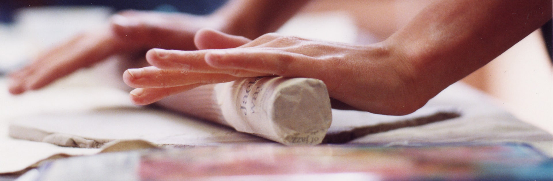 student rolling clay