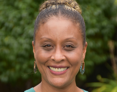 smiling black woman with hair up in a bun