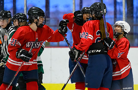 girls ice hockey players high fiving