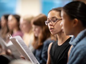 A diverse group of female students singing