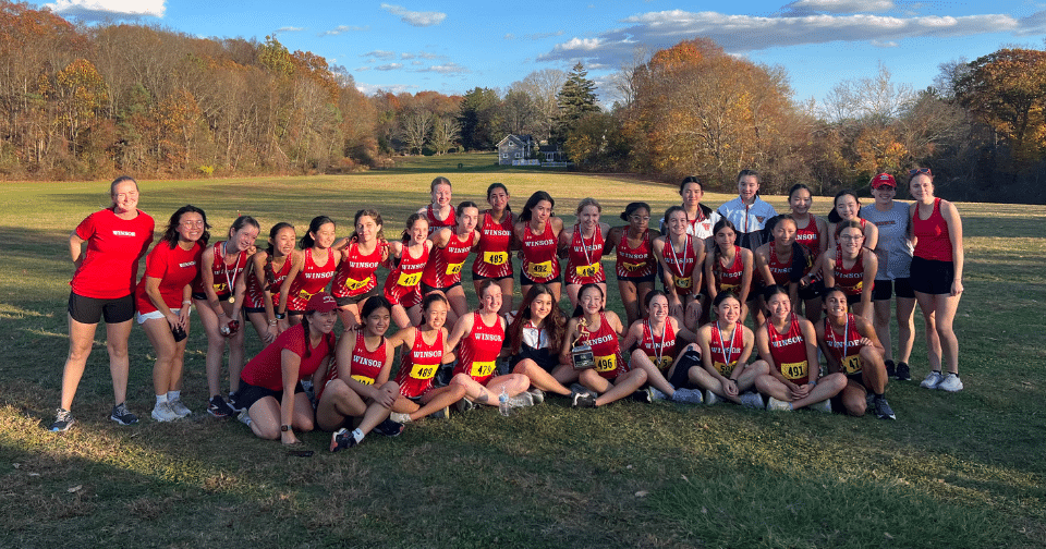 Cross country athletes pose with a trophy