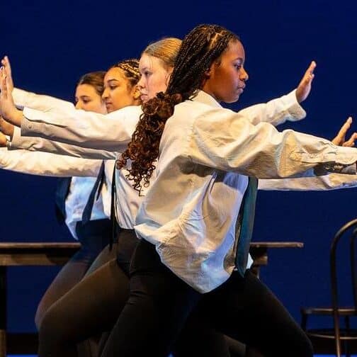 Students in a dance line on stage