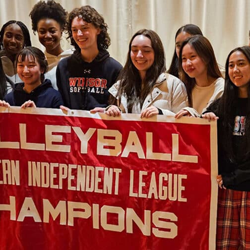 Volleyball athletes hold a banner