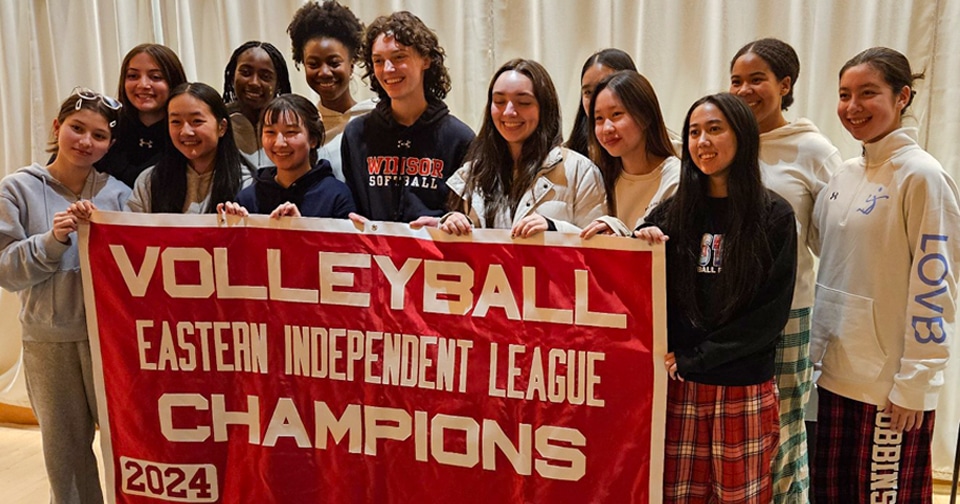 Volleyball athletes hold a banner