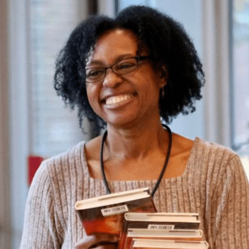 Female author holds a stack of books